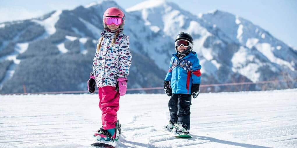Two kids snowboarding
